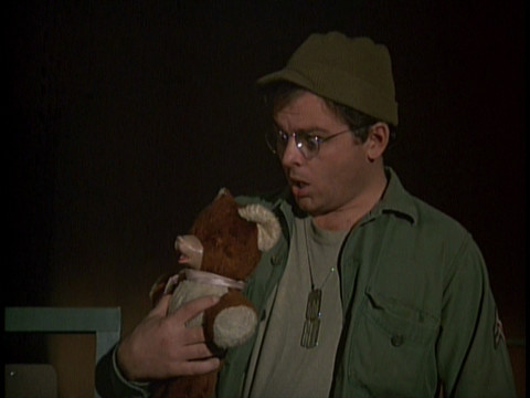 Screenshot featuring Gary Burghoff as Radar, holding his teddy bear and looking surprised