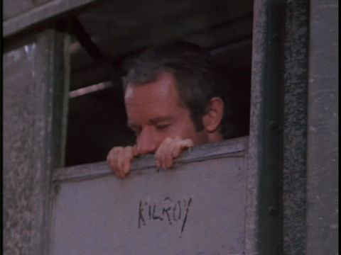 Screenshot featuring Mike Farrell as B.J. reenacting the famous Kilroy Was Here drawing/slogan from World War II