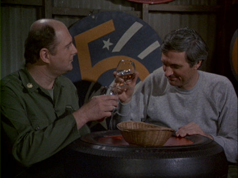 Still from the M*A*S*H episode Sons and Bowlers showing Charles and Hawkeye toasting.