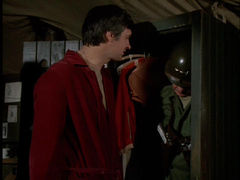 Hawkeye looking at a dead body in a closet