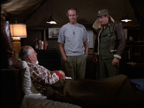 Charles wearing a jacket that is too small for him in Colonel Potter's tent
