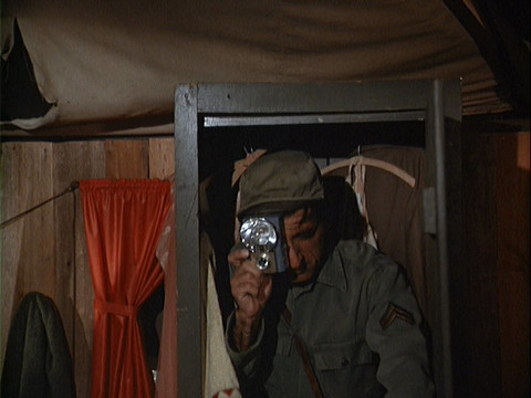Klinger in a closet taking a photograph