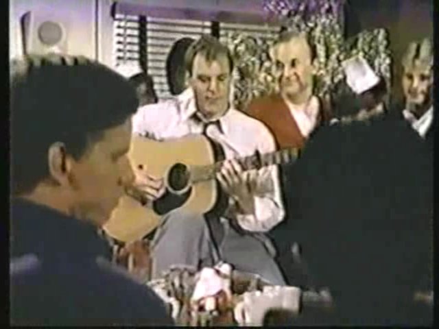Still from the AfterMASH episode showing Dr. Pfeiffer playing his guitar and singing.