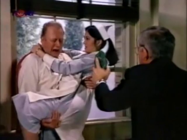 Still from the AfterMASH episode By the Book showing Father Mulcahy, Soon-Lee, and a patient.