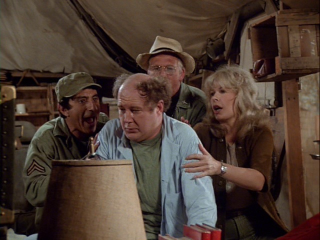 Still from the MASH episode Back Pay showing Klinger, Charles, Father Mulcahy, and Margaret