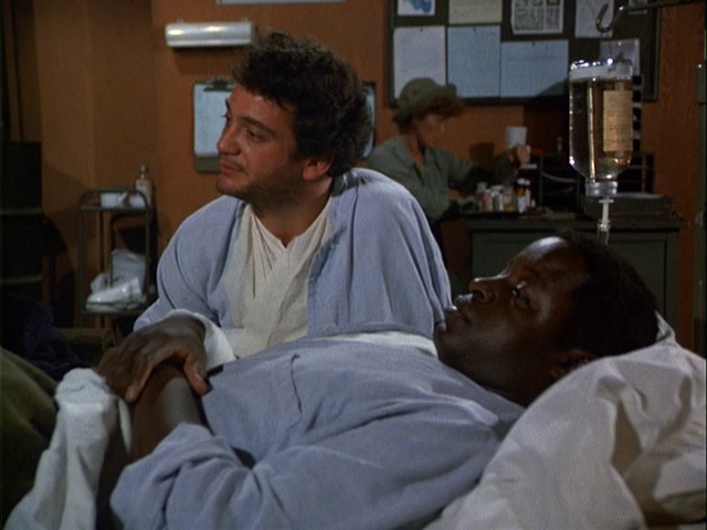 Still from the MASH episode Private Finance showing Philip Simms as Corporal Vitello and Art Evans as Corporal Dolan